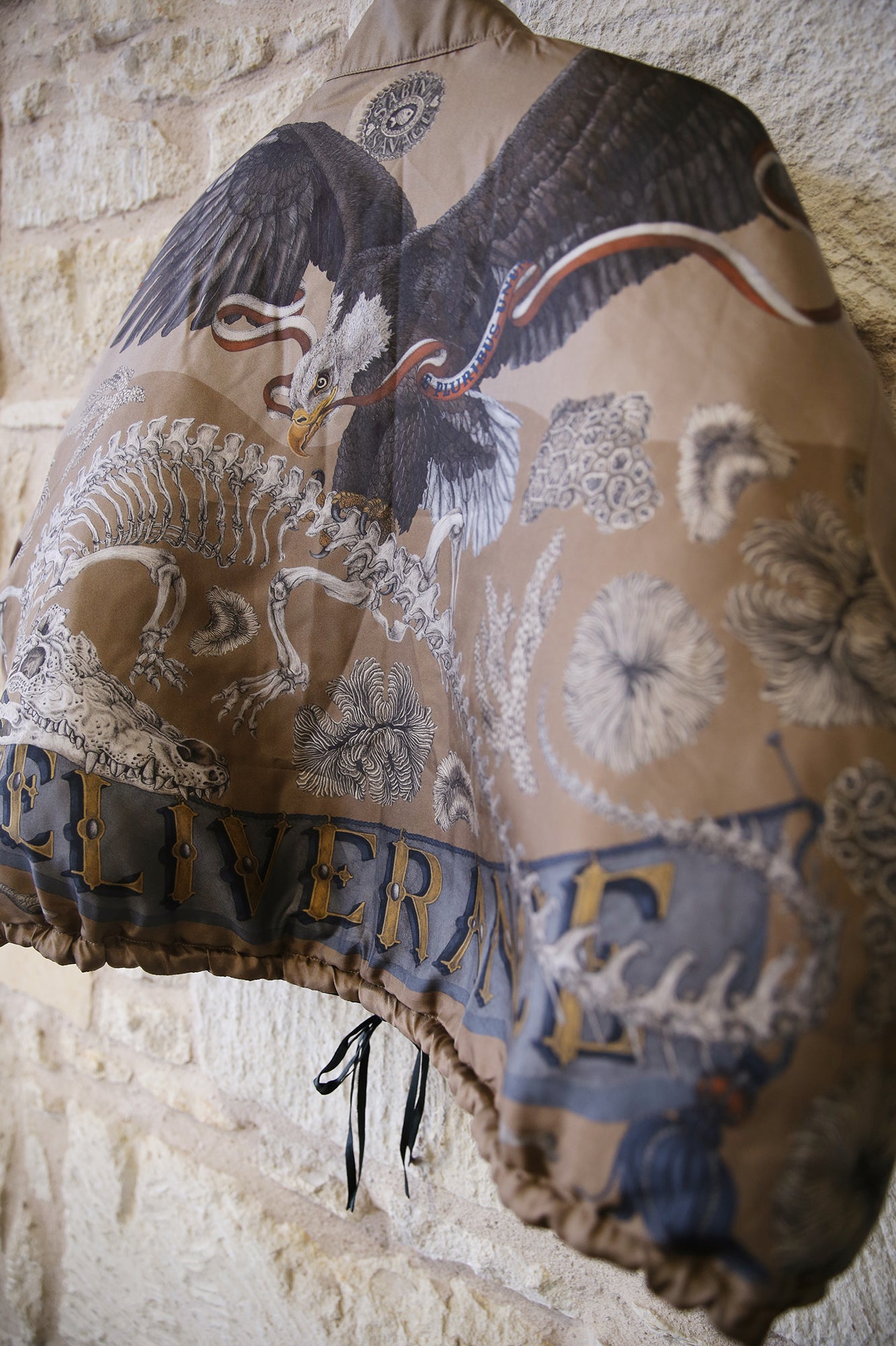 Decorative pillow with eagle design on a stone wall background